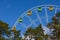 Colorful booths on a Ferris wheel against a clear blue cloudless sky. Ferris Wheel is in the park