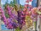 A colorful bouquet of wild flowers on the windowsill of a city apartment. Lupins flowers on urban background.