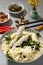 Colorful bowl of assorted noodles, fish, and vegetables, with a pair of chopsticks