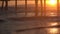 Colorful, bright orange sunset under an ocean pier