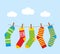 Colorful bright socks on a rope with clothespins against a background of sky and clouds.