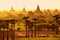 Colorful bright sunrise in with temples, fields and working cattle, Bagan