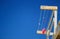 Colorful brightly clothespins and pink rag hanging on rope at the rescue station on background of blue sky