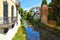 Colorful buildings, architecture, water reflections on city canal and old facade with blue sky in Padua Veneto, italy