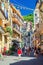 Colorful buildings houses with flags rows, balconies, shutter windows on narrow street of typical traditional fishing village