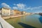 Colorful buildings line the banks of the Arno River in the Tuscan city of Pisa, Italy