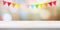 Colorful bunting party flags hanging onblur abstract bokeh light and white marble table background, birthday, anniversary,