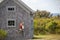 Colorful buoys on the side of a wooden cape style home