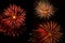Colorful bursts of fireworks trio against black sky