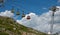 Colorful cable cars reach the green mountain top of La Meije on sunny summer day