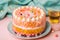 Colorful cake with candies on a pink background, close-up