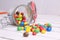 Colorful candles spilling out of a topple-over glass jar to a rustic wooden table