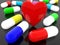 Colorful capsules of medicine and red heart on a black background