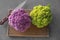 Colorful cauliflowers with knife on wooden board