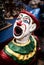 Colorful ceramic clown figurine with wide open mouth and vibrant, painted clothing.