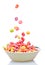 Colorful cereal falling on a white bowl