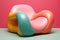 A colorful chair, in the style of playful, dreamlike imagery, rendered in cinema4d, soft pastel tones, biomorphic forms