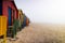 Colorful changing rooms at Muizenberg beach in mist