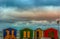 Colorful changing rooms  in St James beach Cape Town under a cloudy sky and sunset