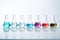 Colorful chemicals in lab flasks on a white table. Scientific experimentation setup for research and analysis.