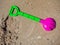 Colorful children`s beach toys on sand background