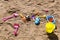 Colorful children\'s toys scattered on the sand at the beach