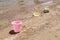Colorful children\'s toys scattered on the sand at the beach