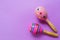 Colorful children`s wooden rattles on a pink background.