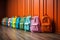 Colorful childrens schoolbags on a wooden floor, blue room
