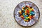 Colorful chocolate candies on the beautiful ornamental plate on the table