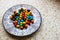 Colorful chocolate candies on the beautiful ornamental plate on the table