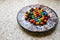 Colorful chocolate candies on the beautiful ornamental plate on the table