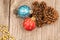 Colorful Christmas baubles, golden beads and pine cones top view