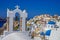 Colorful city of Oia in Santorini greece with a bell cross and domes