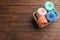 Colorful clews of threads in wicker basket on wooden table