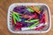 Colorful clothes pegs in plastic basket