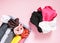 Colorful clothes vertical storage in wardrobe. Items of clothing in textile box on soft pink background