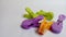 Colorful clothespin isolated on a white background. Clothespins are orange, green and purple. Close-up photo.