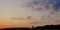 Colorful cloudy evenig over silhouette of hills and trees