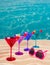 Colorful cocktail in a row with cherry on tropical sand beach