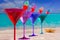 Colorful cocktail in a row with cherry on tropical sand beach