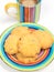 Colorful coffee cup with saucer and cookies