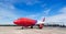 Colorful commercial airplane on runway with blue sky