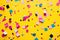a colorful confetti on a yellow surface