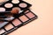 Colorful contouring palettes and brushes on beige background, closeup. Professional cosmetic product