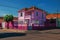 Colorful corner townhouse in an empty street with tree on sidewalk, in a sunny day at San Manuel.