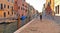 Colorful corners and old buildings with water canal and woman in vanishing point in Venice, Italy