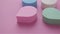 Colorful cosmetic makeup sponges on pink background panning shot