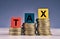 Colorful cube with word TAX and stacking coin on wooden table