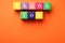 Colorful cubes with phrase Thank You on orange background, top view